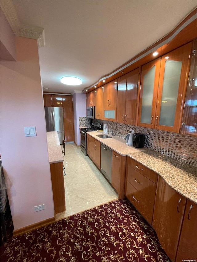 kitchen with light stone countertops, sink, stainless steel appliances, decorative backsplash, and light tile patterned floors