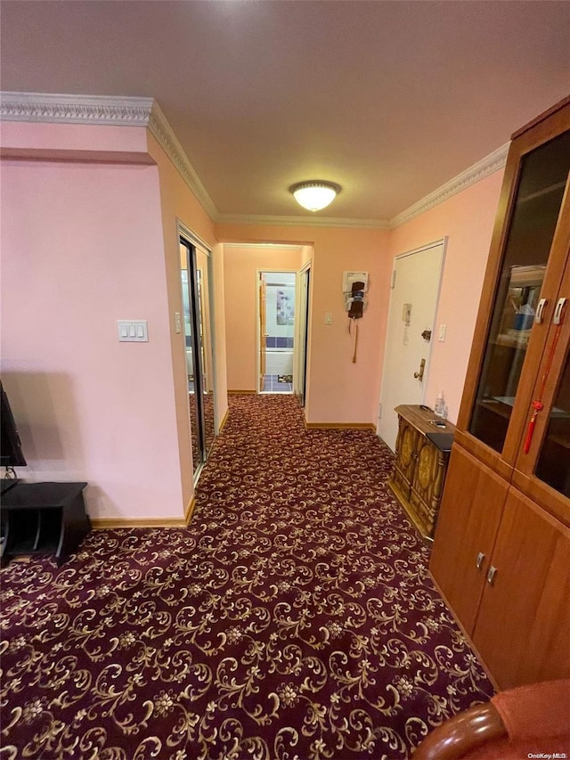 corridor featuring dark colored carpet and crown molding