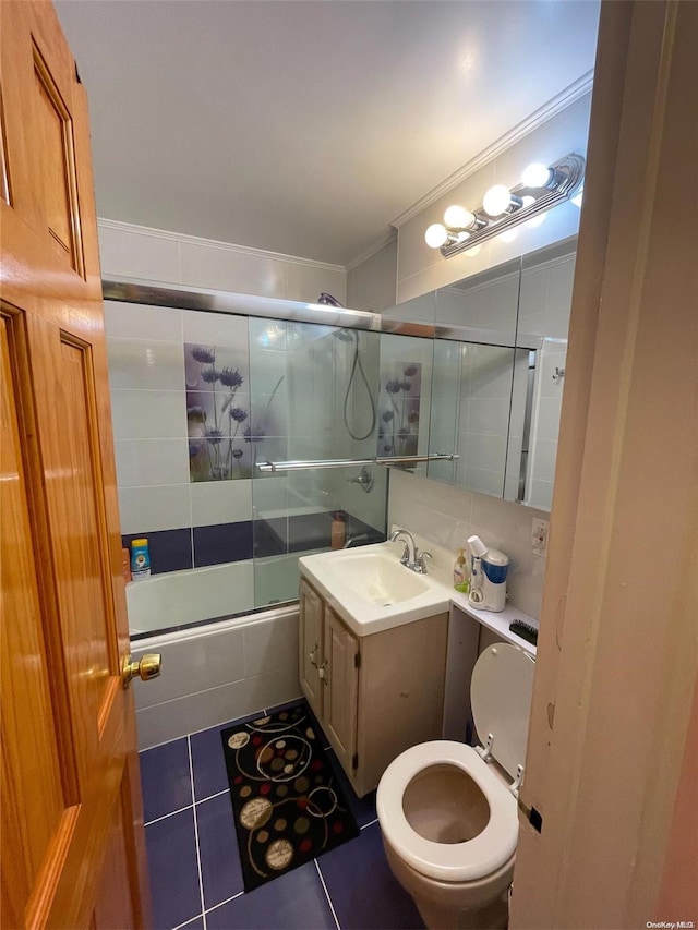 full bathroom featuring vanity, shower / bath combination with glass door, tile patterned floors, crown molding, and toilet