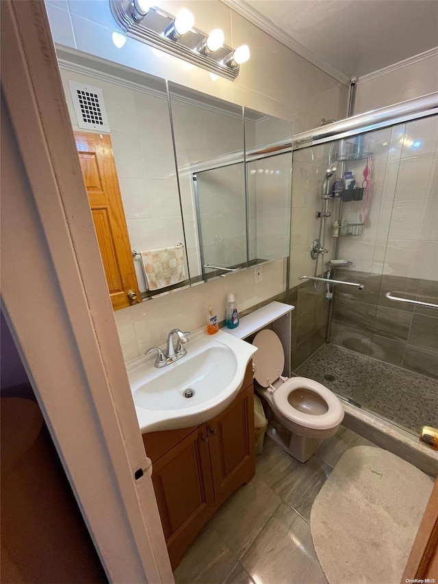 bathroom featuring vanity, tile patterned floors, crown molding, toilet, and walk in shower