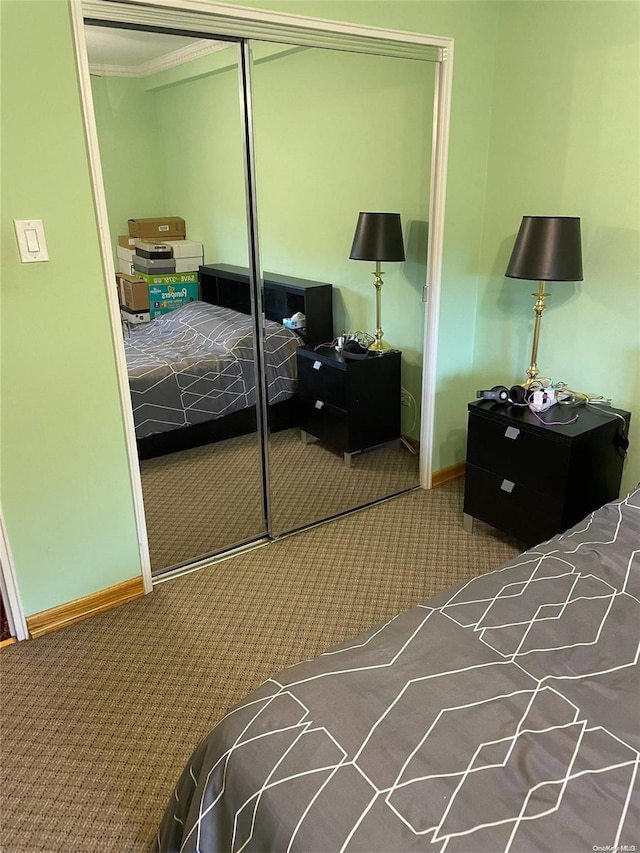 carpeted bedroom featuring crown molding and a closet