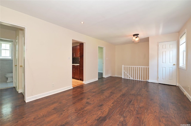 unfurnished room with plenty of natural light and dark hardwood / wood-style floors