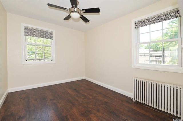 empty room with ceiling fan, radiator heating unit, and dark hardwood / wood-style flooring