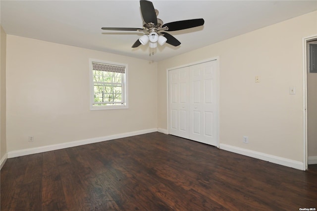 unfurnished bedroom with dark wood-type flooring, ceiling fan, and a closet