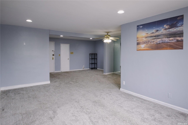 empty room featuring ceiling fan and carpet