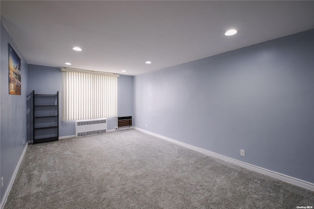 spare room with carpet flooring and radiator heating unit