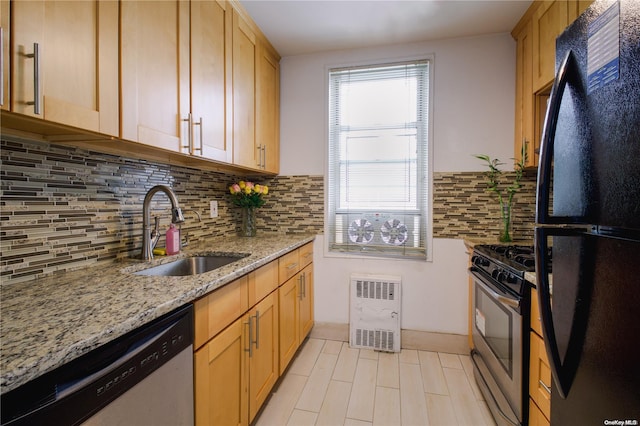 kitchen featuring light stone countertops, stainless steel appliances, tasteful backsplash, and sink