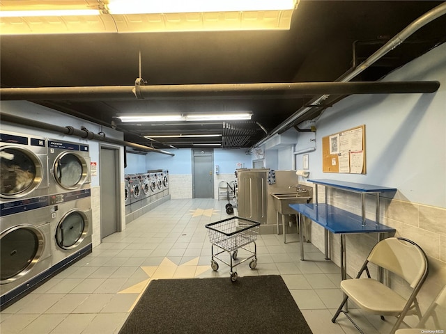 basement featuring washing machine and dryer, light tile patterned flooring, and stacked washer / dryer