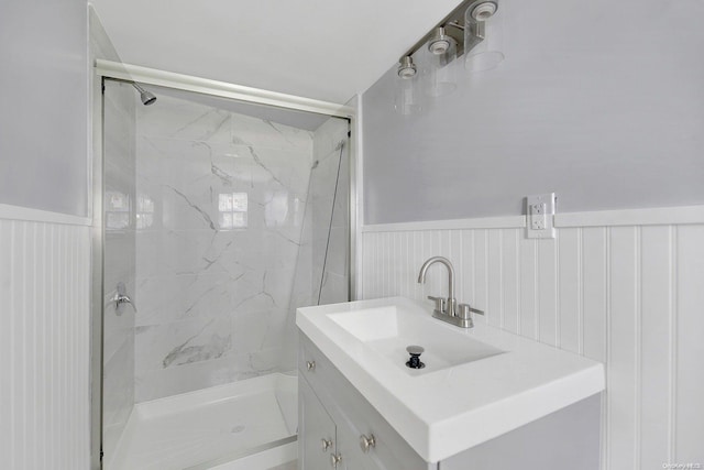 bathroom with a tile shower and vanity