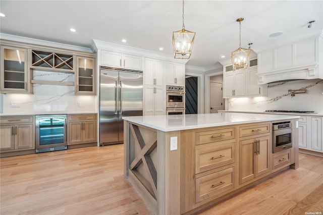 kitchen featuring a large island, wine cooler, light hardwood / wood-style flooring, decorative light fixtures, and appliances with stainless steel finishes