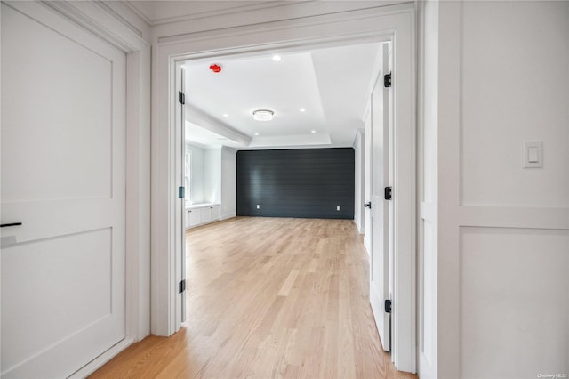 hallway featuring light hardwood / wood-style floors and a raised ceiling