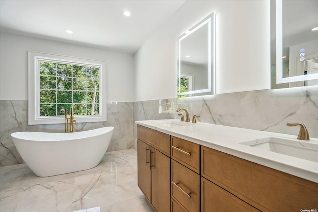 bathroom featuring a bathtub, vanity, and tile walls