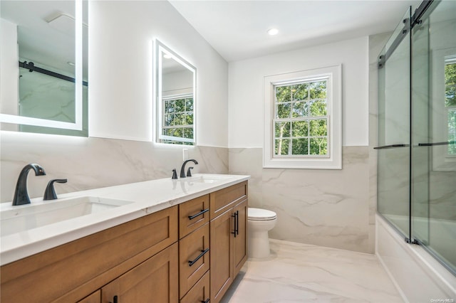 bathroom featuring vanity, tile walls, and toilet