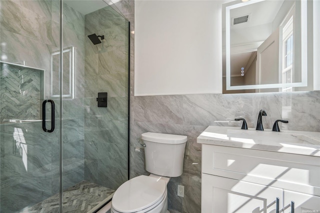 bathroom featuring vanity, a shower with shower door, tile walls, and toilet