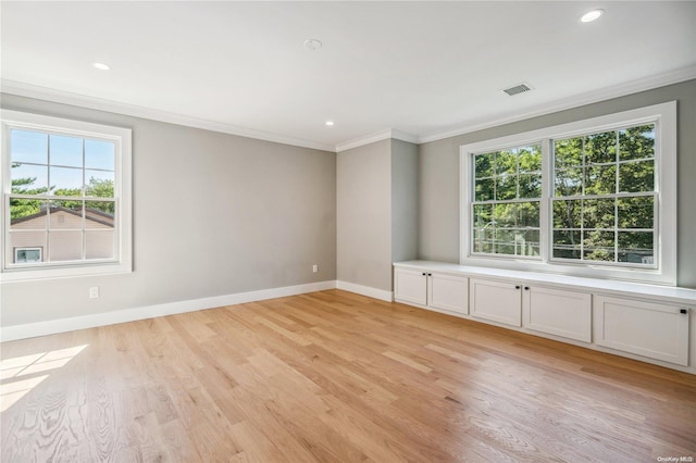 unfurnished room featuring ornamental molding and light hardwood / wood-style flooring