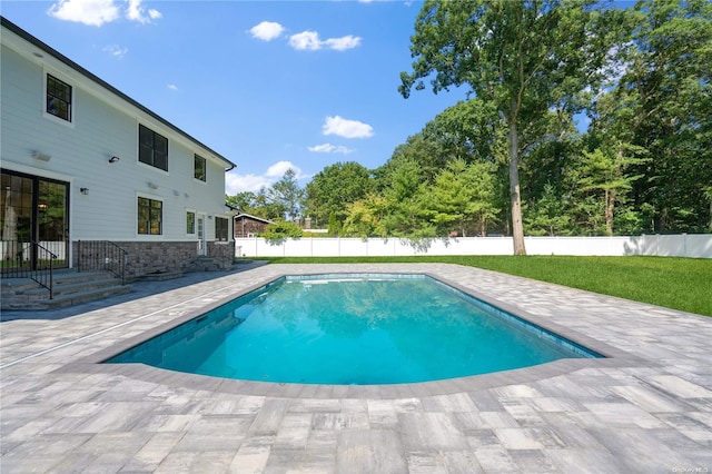 view of swimming pool featuring a patio area and a lawn