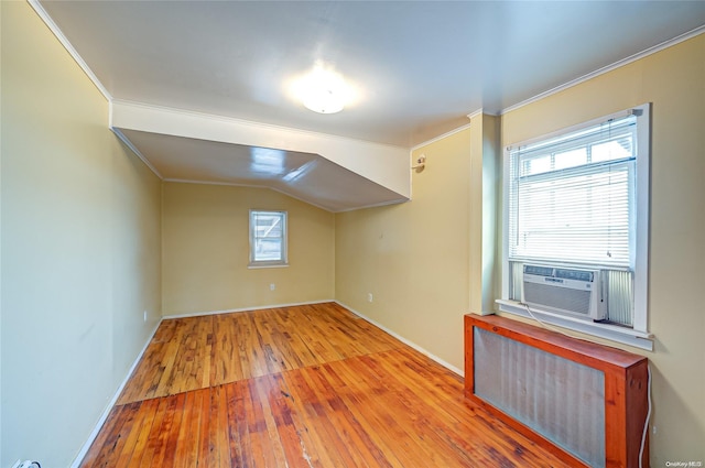 bonus room with cooling unit, lofted ceiling, light hardwood / wood-style flooring, and radiator heating unit