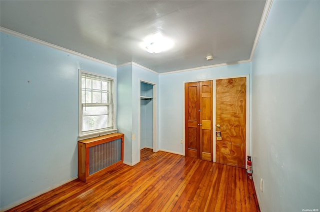 unfurnished bedroom with crown molding and hardwood / wood-style floors