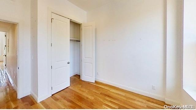 unfurnished bedroom featuring a closet and light hardwood / wood-style floors