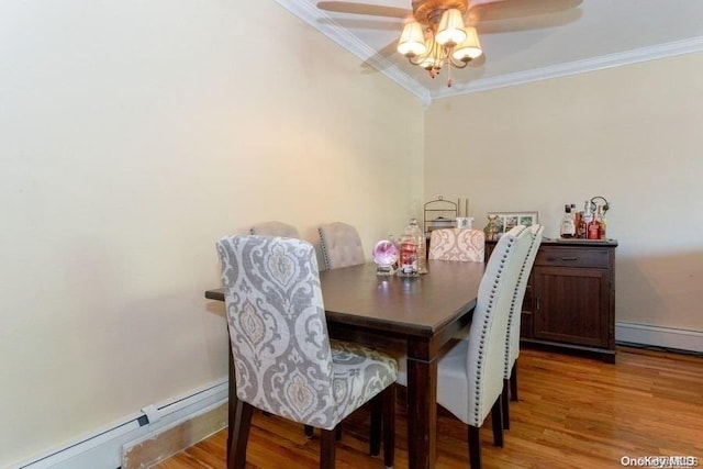 dining room featuring crown molding, ceiling fan, a baseboard radiator, and wood-type flooring