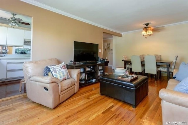 living room featuring ceiling fan, light hardwood / wood-style floors, and ornamental molding