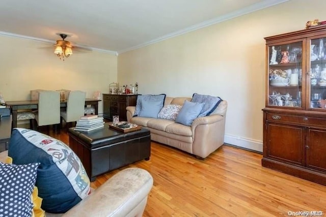 living room featuring ceiling fan, light wood-type flooring, and crown molding