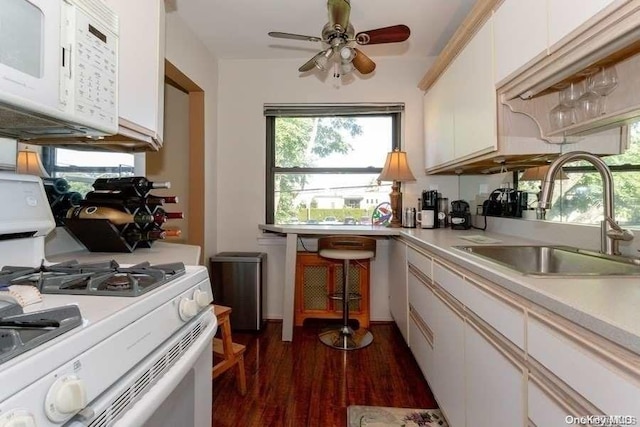 kitchen featuring white appliances, sink, dark hardwood / wood-style floors, ceiling fan, and white cabinetry