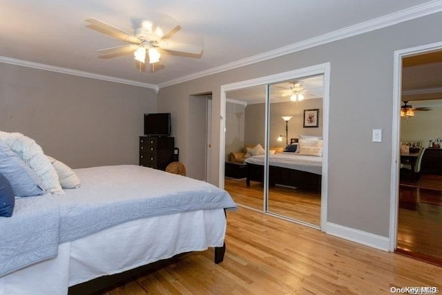 bedroom with wood-type flooring, a closet, ceiling fan, and crown molding