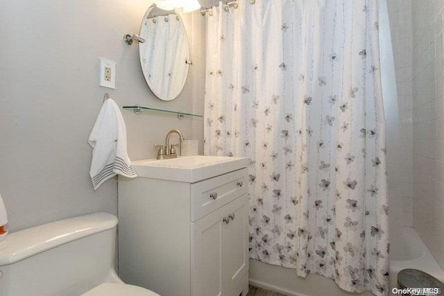 full bathroom featuring shower / bath combination with curtain, vanity, and toilet