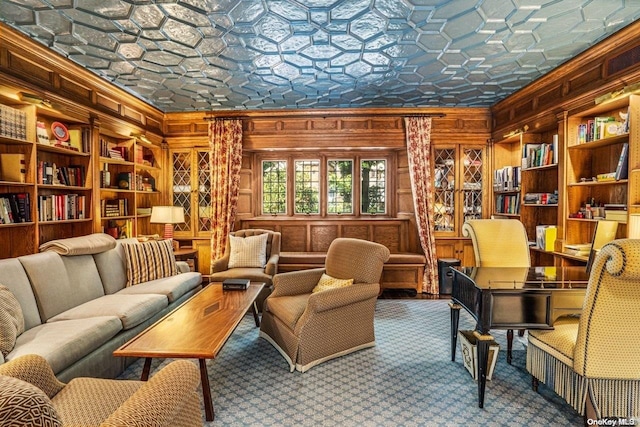 sitting room featuring built in features, ornamental molding, and wood walls