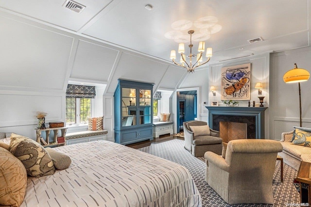 bedroom featuring a high end fireplace, ornamental molding, and a notable chandelier