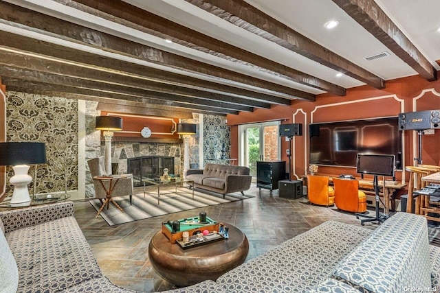 living room featuring beamed ceiling, dark parquet flooring, and a fireplace