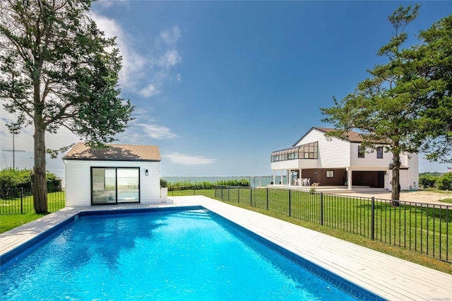 view of swimming pool featuring a lawn and an outbuilding