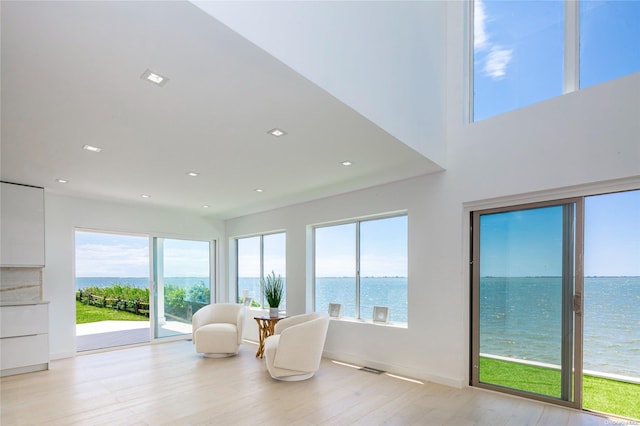 sunroom / solarium featuring a water view and a wealth of natural light