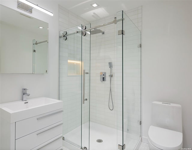 bathroom with vanity, toilet, and a shower with door