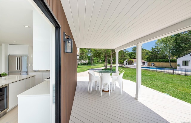 wooden terrace with a fenced in pool and a yard