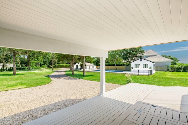 wooden terrace featuring a yard and a swimming pool