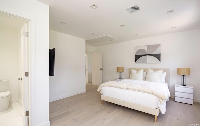 bedroom featuring ensuite bathroom and light wood-type flooring