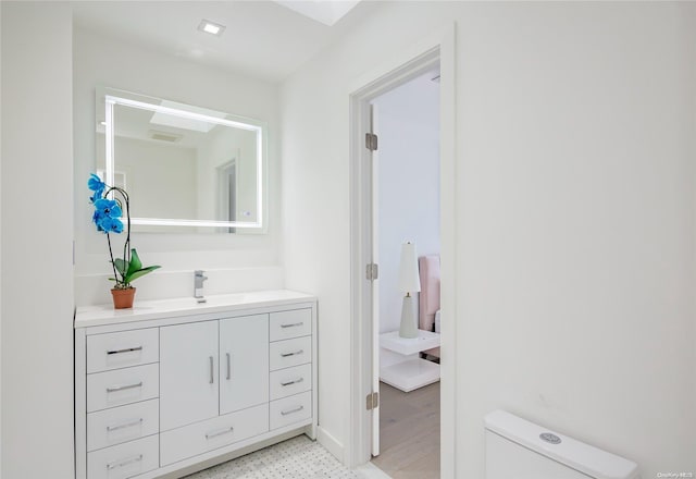 bathroom with vanity, hardwood / wood-style flooring, and toilet