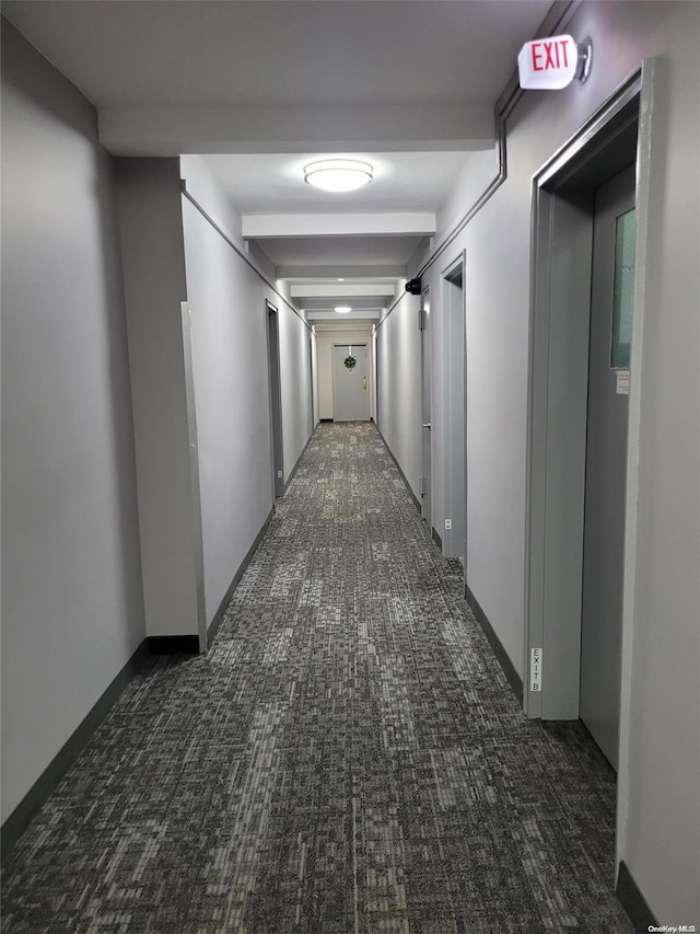 hallway featuring dark colored carpet