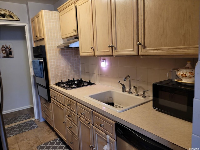 kitchen with gas cooktop, light brown cabinetry, backsplash, sink, and oven