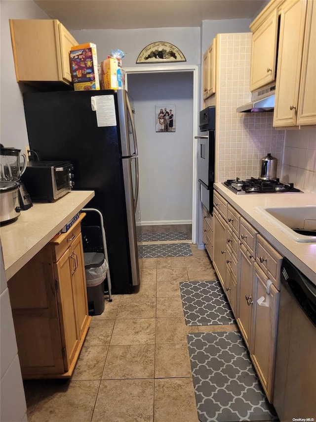 kitchen with appliances with stainless steel finishes, tasteful backsplash, extractor fan, light brown cabinets, and light tile patterned flooring