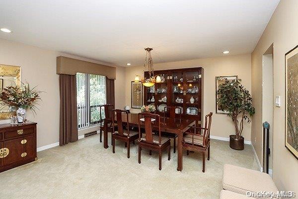 carpeted dining space featuring a notable chandelier