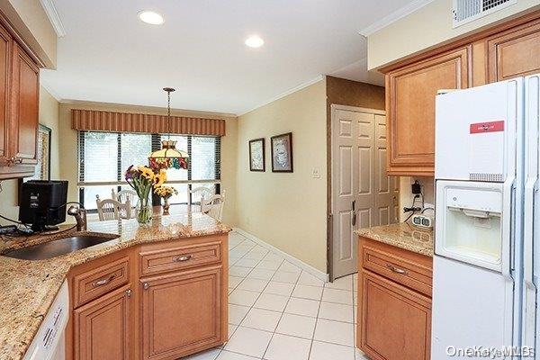 kitchen with pendant lighting, white appliances, crown molding, and sink