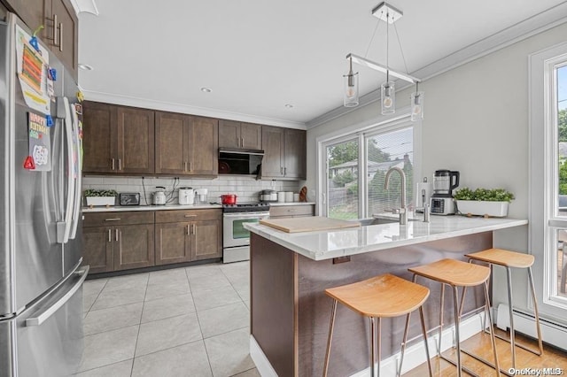 kitchen with a breakfast bar area, kitchen peninsula, light tile patterned floors, and appliances with stainless steel finishes