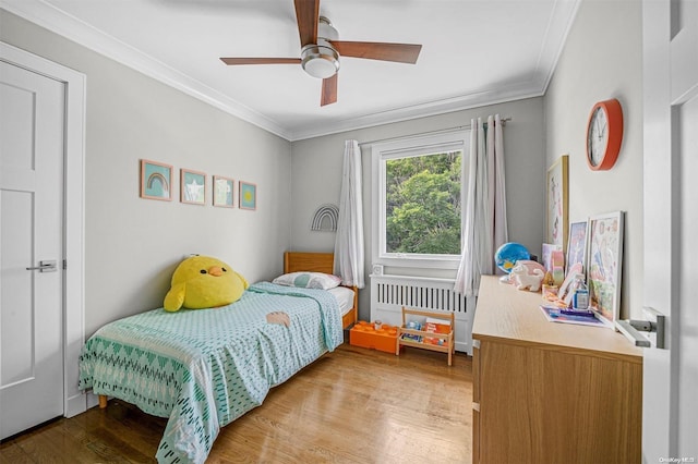 bedroom with hardwood / wood-style floors, ceiling fan, crown molding, and radiator