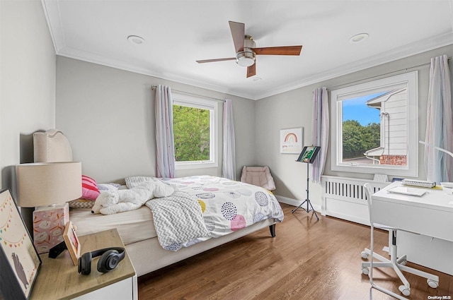 bedroom featuring hardwood / wood-style flooring, ceiling fan, and ornamental molding