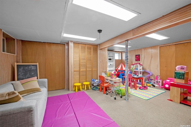 playroom featuring carpet and wooden walls