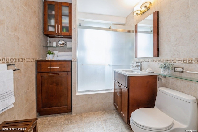 bathroom with tile patterned floors, toilet, decorative backsplash, vanity, and tile walls