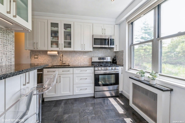 70-25 Yellowstone Blvd Unit 2T, Forest Hills, NY 11375 - kitchen featuring appliances with stainless steel finishes, white cabinetry, and plenty of natural light